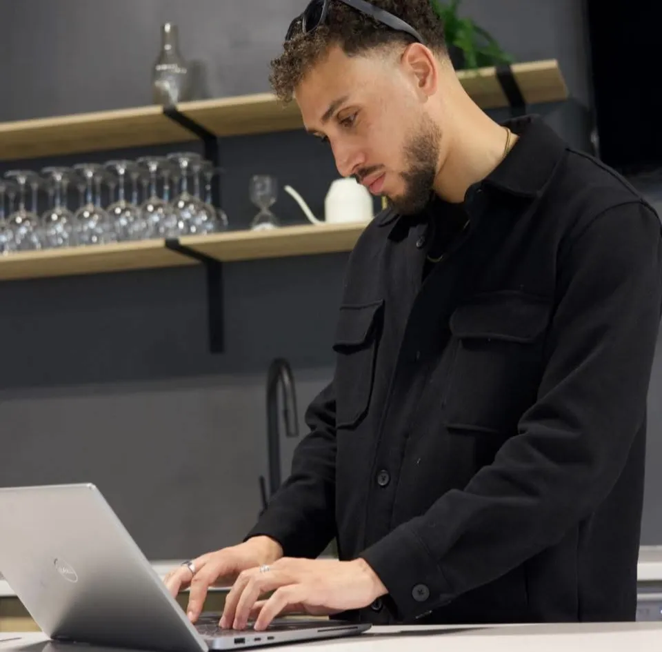 Riyad, ingénieur logiciel et fondateur d'Elite Profits Inc., au travail sur son ordinateur